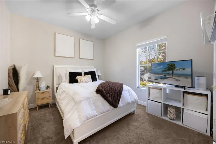 Carpeted bedroom featuring ceiling fan