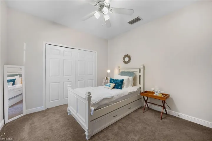 Carpeted bedroom with a closet and ceiling fan