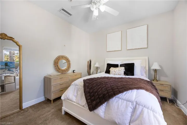 Carpeted bedroom featuring ceiling fan
