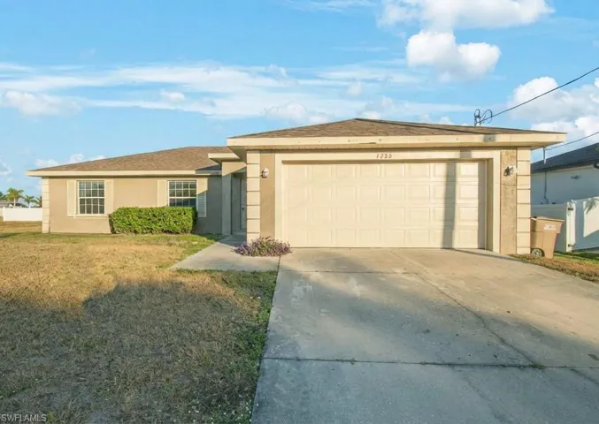 Single story home with stucco siding, driveway, a front lawn, and an attached garage