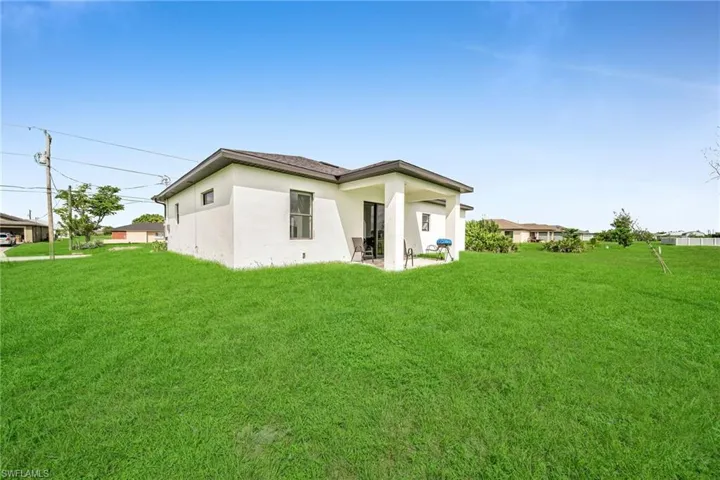 Rear view of house featuring a lawn and a patio