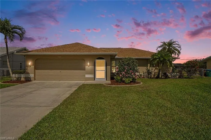 Ranch-style home featuring an attached garage, stucco siding, and driveway