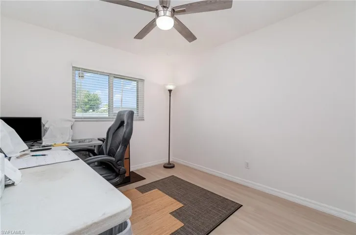Home office with light wood-type flooring and ceiling fan