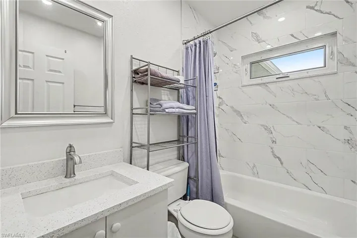 Bathroom featuring vanity and shower / tub combo with curtain