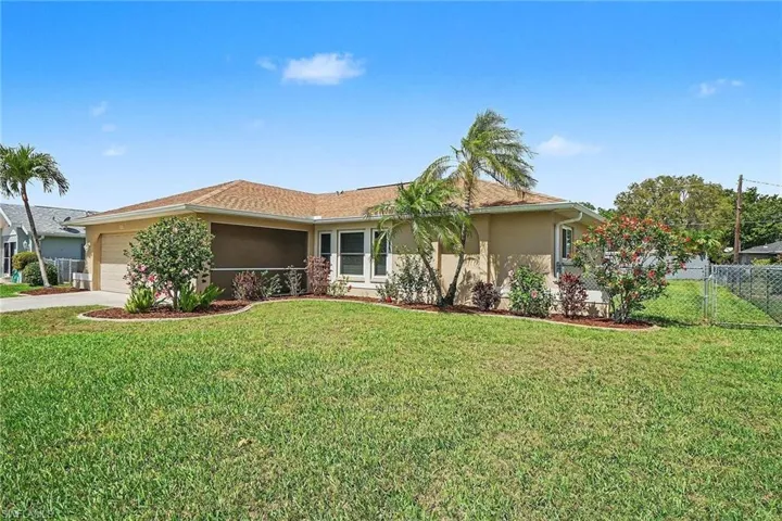 Single story home featuring stucco siding, an attached garage, concrete driveway, and a gate