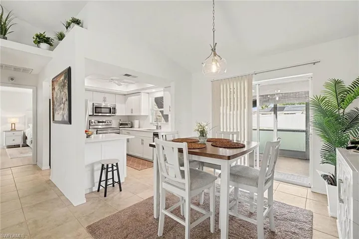 Dining space featuring lofted ceiling, light tile patterned flooring, and ceiling fan