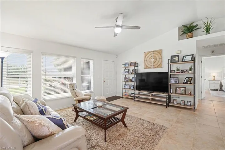 Living room with lofted ceiling and a ceiling fan