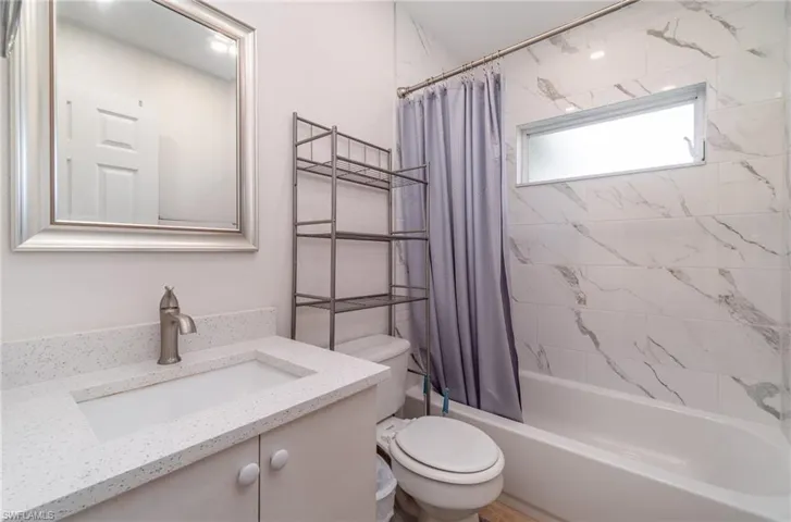 Bathroom with vanity and shower / tub combo with curtain