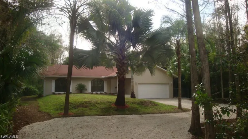 Ranch-style house featuring driveway, a front lawn, stucco siding, and an attached garage