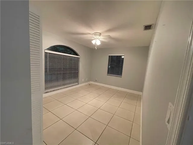 Unfurnished room featuring light tile patterned flooring and ceiling fan