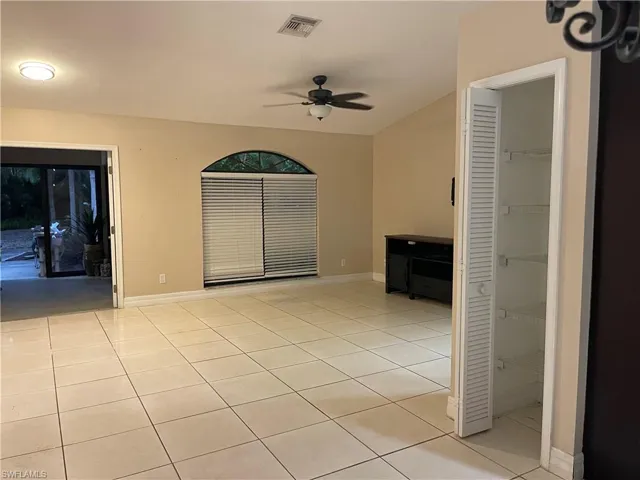 Empty room featuring light tile patterned floors and a ceiling fan