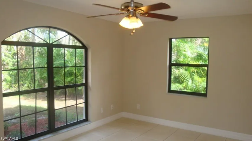 Spare room with ceiling fan and light tile patterned flooring