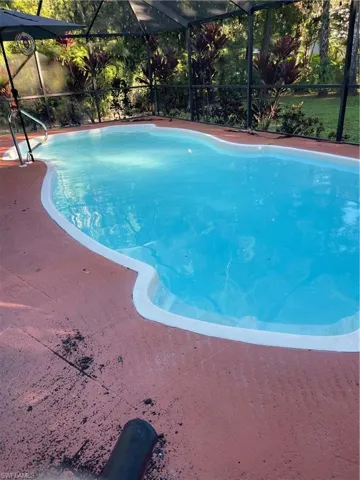 Outdoor pool featuring glass enclosure and a sunroom