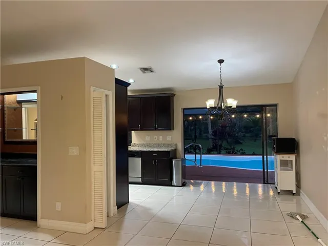 Kitchen with light tile patterned floors, a chandelier, pendant lighting, stainless steel dishwasher, and recessed lighting