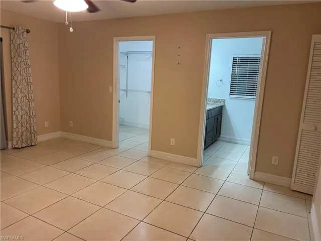 Unfurnished room featuring light tile patterned floors and ceiling fan