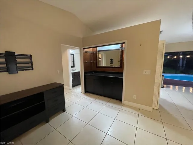 Hall featuring light tile patterned flooring and lofted ceiling