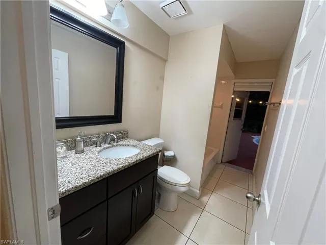 Full bath with vanity, light tile patterned flooring, and bathing tub / shower combination