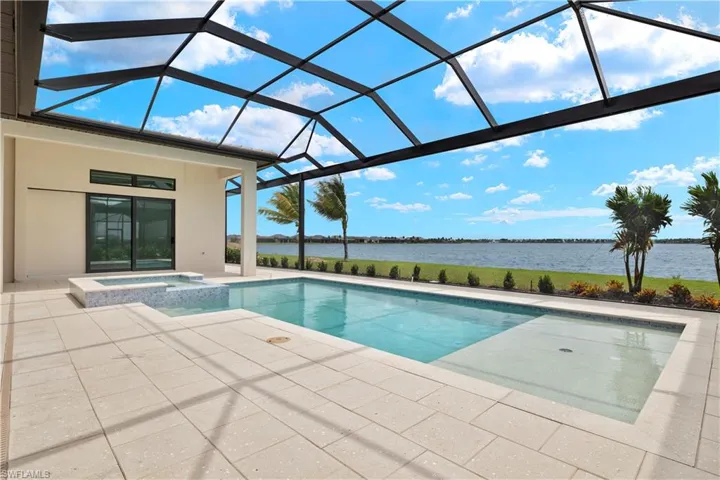 View of pool featuring a lanai, an in ground hot tub, a patio, and a water view