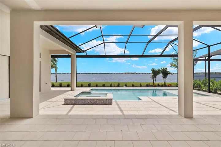 View of swimming pool with glass enclosure, an in ground hot tub, a patio, and area for grilling