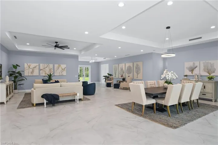 Tiled dining room with ceiling fan and a raised ceiling