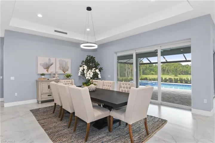 Tiled dining room featuring a tray ceiling