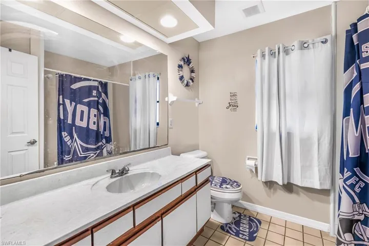 Bathroom featuring tile patterned flooring, vanity, and toilet