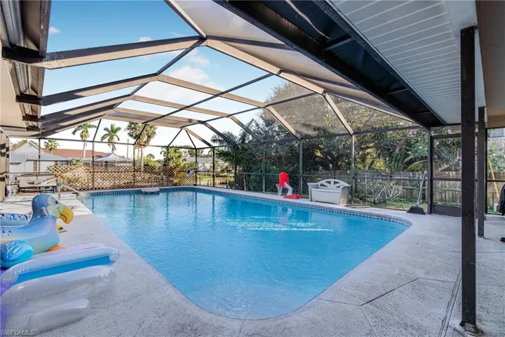 View of swimming pool featuring a patio and a lanai