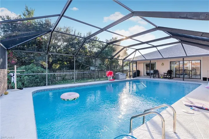 View of swimming pool with glass enclosure and a patio area