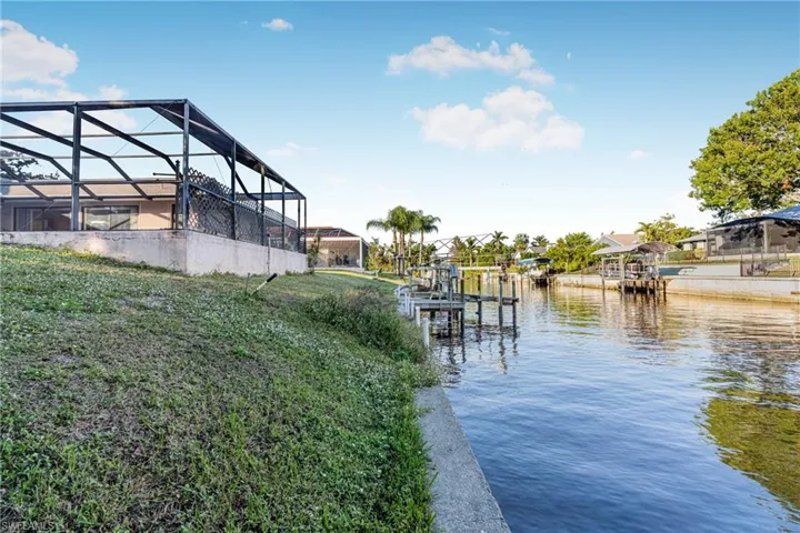 View of dock with a lanai and a water view