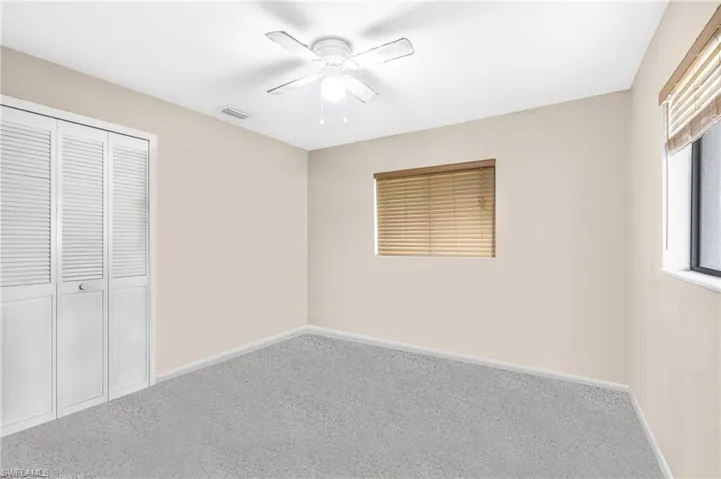 Unfurnished bedroom featuring carpet, ceiling fan, and a closet