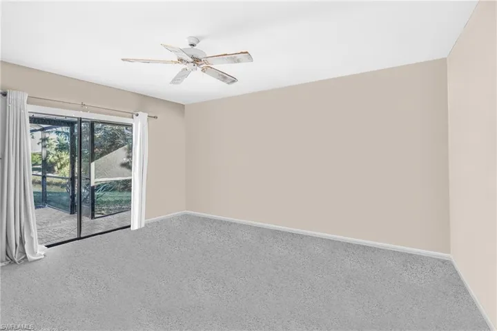 Carpeted empty room featuring ceiling fan