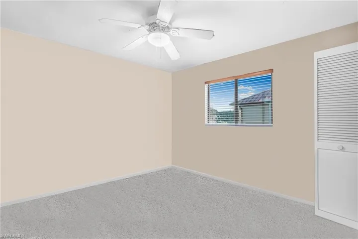 Carpeted spare room with ceiling fan