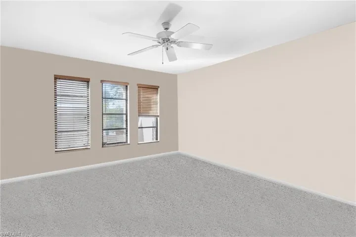 Carpeted empty room featuring ceiling fan