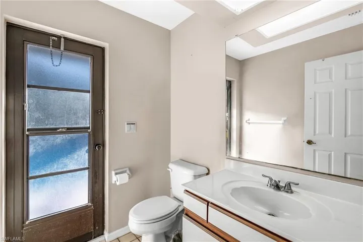 Bathroom featuring tile patterned flooring, vanity, and toilet
