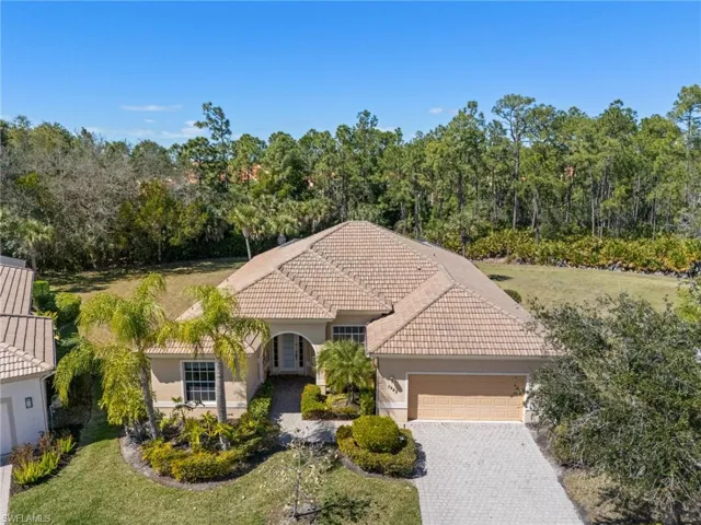 Mediterranean / spanish house with an attached garage, stucco siding, a tile roof, decorative driveway, and a front yard