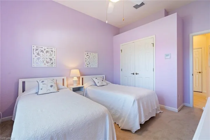 Bedroom featuring light carpet, a closet, and ceiling fan