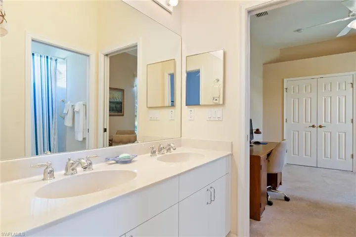 Full bath featuring double vanity, light colored carpet, and ceiling fan