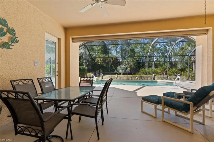 View of patio / terrace with an outdoor pool, a sunroom, a ceiling fan, outdoor dining space, and a lanai