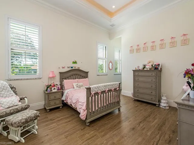 Bedroom with ornamental molding, multiple windows, and dark hardwood / wood-style floors