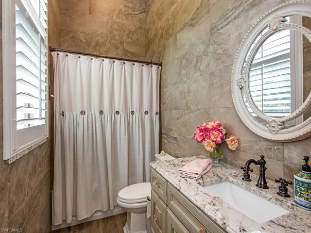 Bathroom with plenty of natural light, vanity, toilet, and wood-type flooring