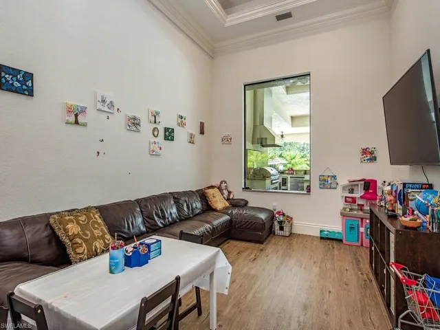 Living room with crown molding and light wood-type flooring
