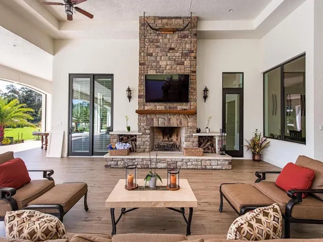Living room featuring a fireplace, a textured ceiling, wood-type flooring, and ceiling fan