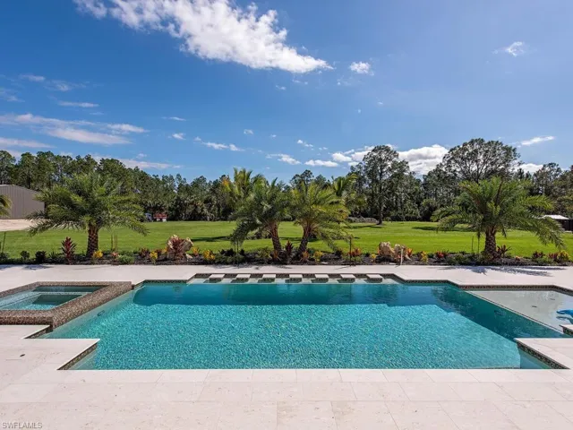 View of pool with a yard and an in ground hot tub