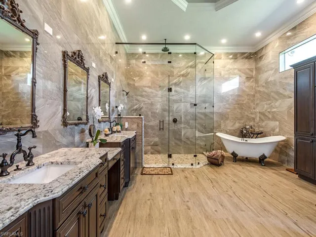Bathroom with vanity, crown molding, tile walls, hardwood / wood-style flooring, and plus walk in shower