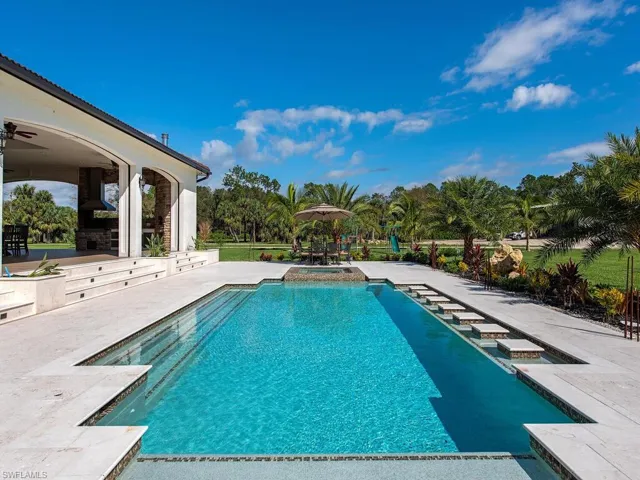 View of swimming pool with ceiling fan and a patio