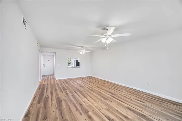 Unfurnished living room with wood finished floors and ceiling fan
