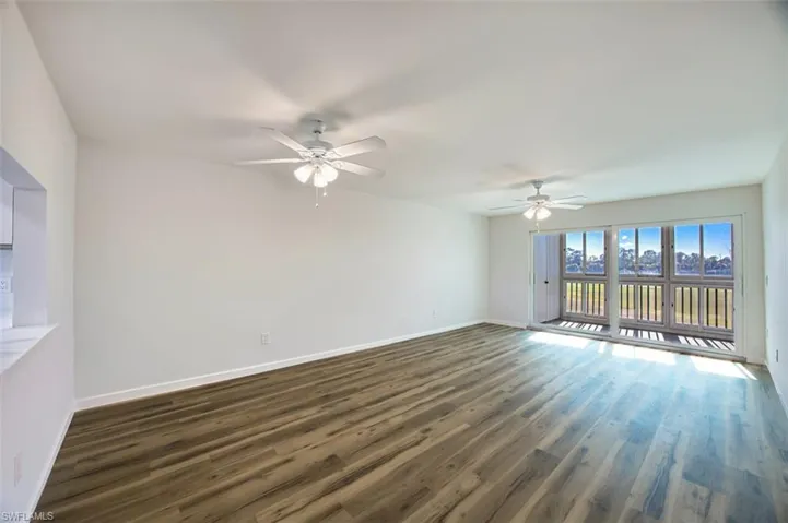 Unfurnished room featuring dark wood-style flooring and ceiling fan