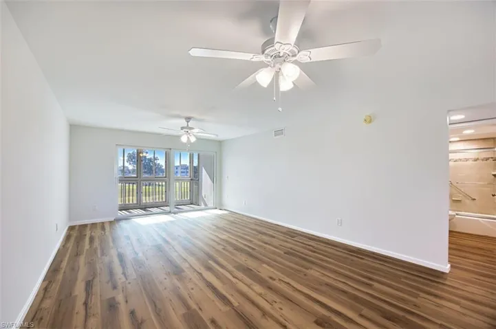 Unfurnished room with dark wood finished floors and a ceiling fan