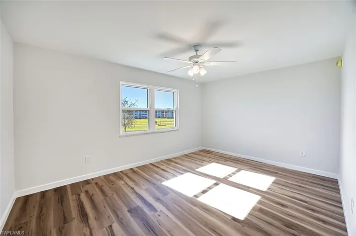 Spare room with wood finished floors and a ceiling fan