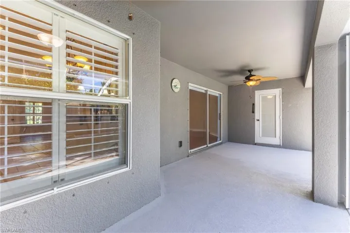 Expansive covered patio featuring a concrete surface, a ceiling fan with integrated lighting, and textured stucco walls